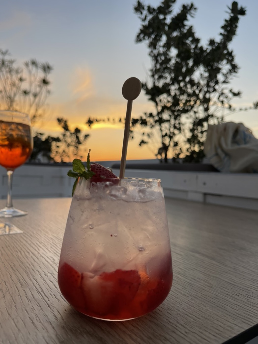 A strawberry cocktail on a rooftop table at sunset