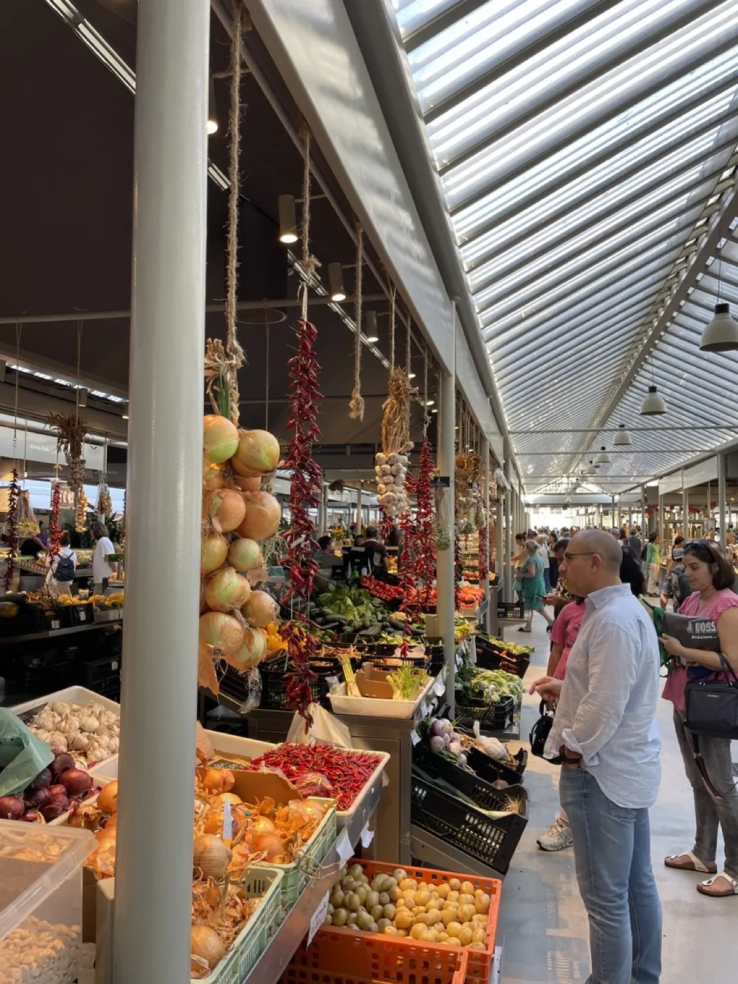Strings of onions and dried chillies hanging over the produce stalls at Mercado do Bolhão in Porto