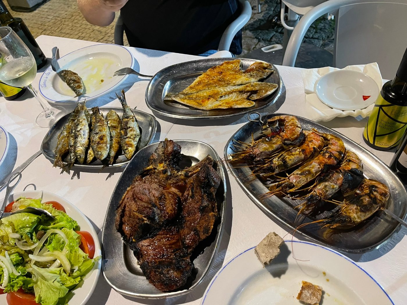 Grilled sardines and a lamb chop platter on a restaurant table
