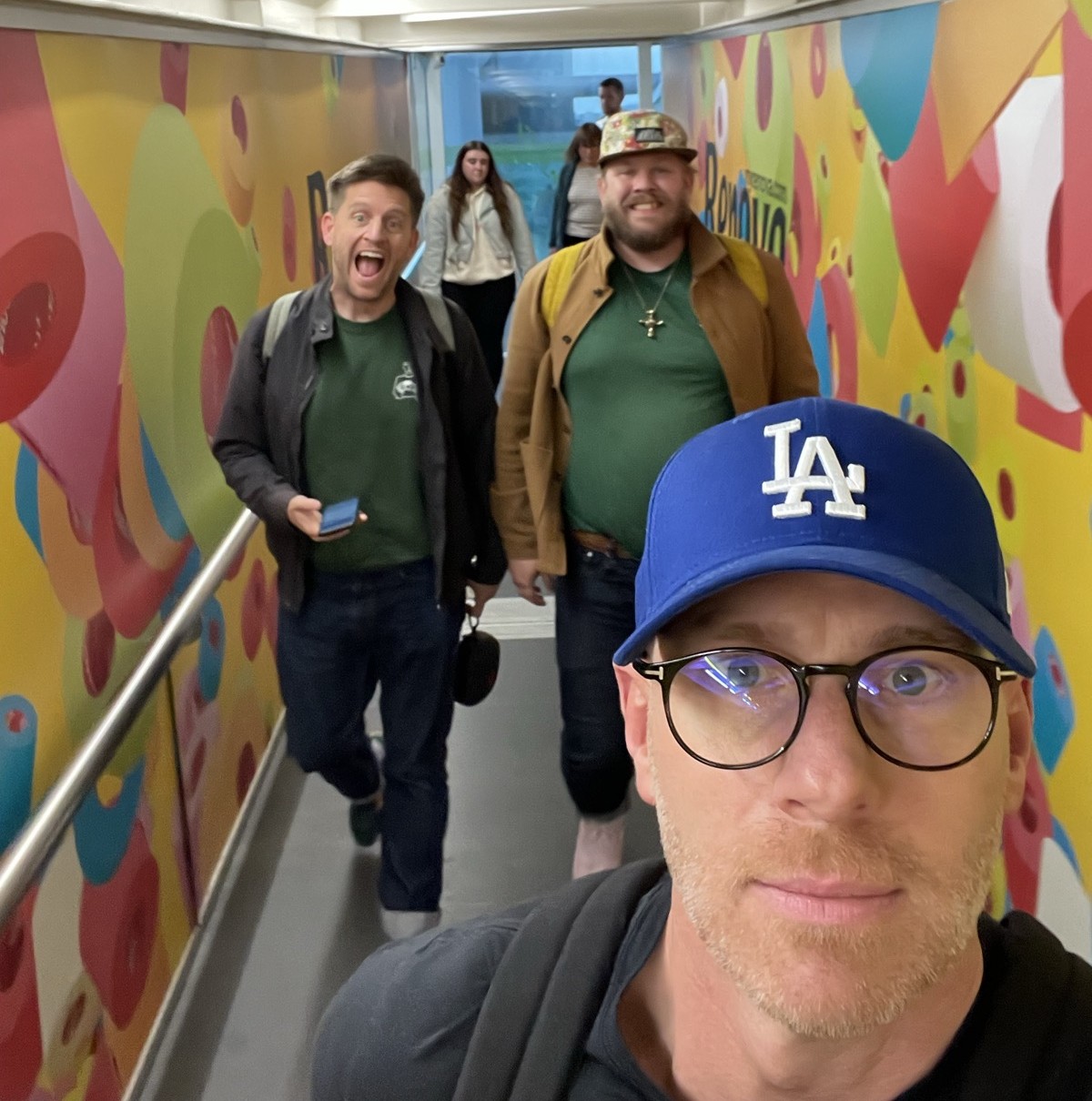 Mat, Dave and Tom arriving in Porto, mid-selfie in a colourfully painted underpass